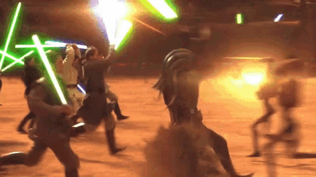 a group of people are holding lightsabers in a dark room