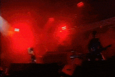 a red light is shining on a stage with a microphone in the foreground