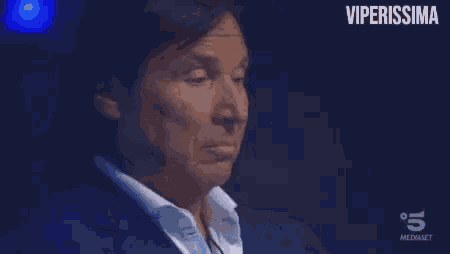 a man in a suit and white shirt is making a funny face and the words viperissima are above him