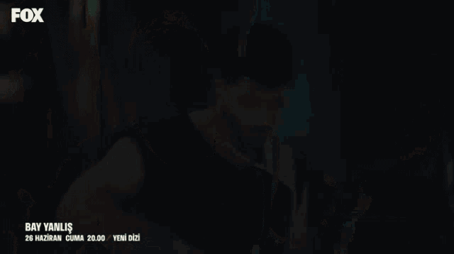 a man in a black tank top with fox written on the bottom right