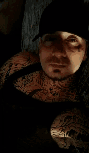 a man with a lot of tattoos on his body is wearing a black hat