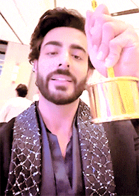 a man with a beard is holding a gold object