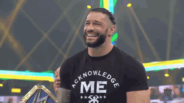 a man wearing a black shirt that says acknowledge me on it