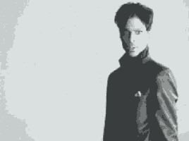 a man in a suit is standing in front of a white wall