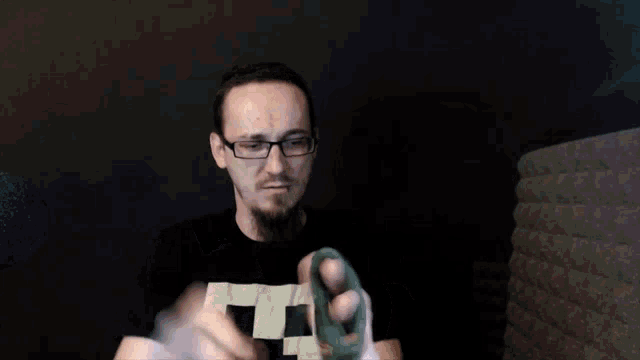 a man wearing glasses and a black shirt with the letter l on the front