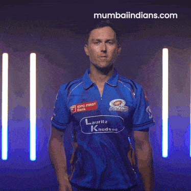 a man wearing a blue shirt that says idfc first on it