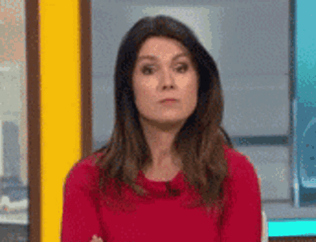 a woman in a red shirt is making a funny face .
