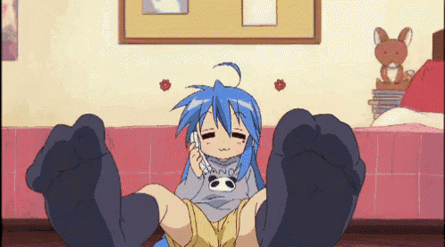 a girl with blue hair is sitting on the floor with her feet up and talking on a cell phone