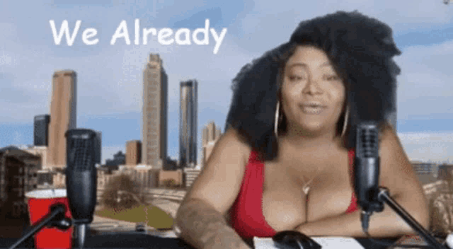 a woman sitting in front of a microphone with the words " we already " behind her