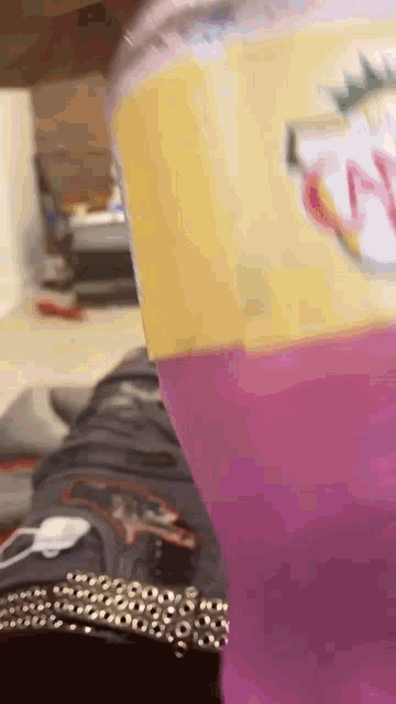 a close up of a purple drink in a plastic cup with a yellow label