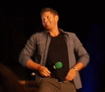 a man is taking off his shirt on a stage and dancing .
