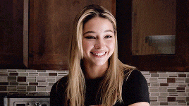 a woman with blonde hair is smiling in a kitchen .