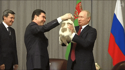 a man in a suit is holding a rabbit in front of a russian flag