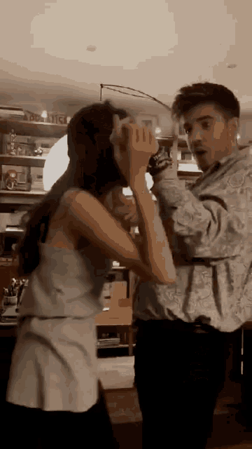 a man and a woman are dancing in a living room with a sign that says abc on it