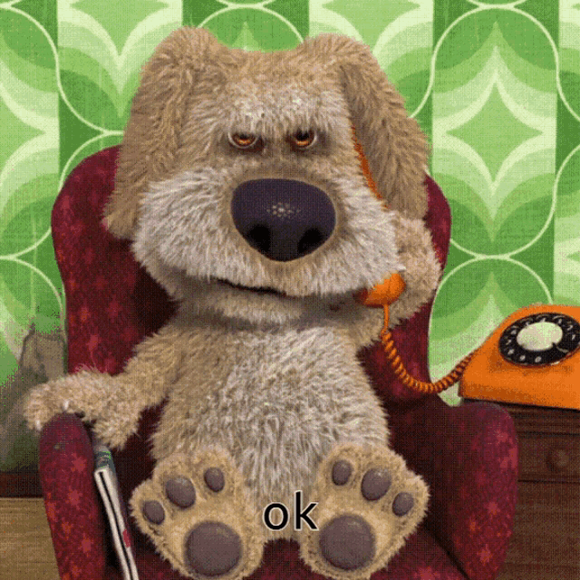 a stuffed dog is sitting in a chair talking on a phone and the word ok is on the bottom of the picture