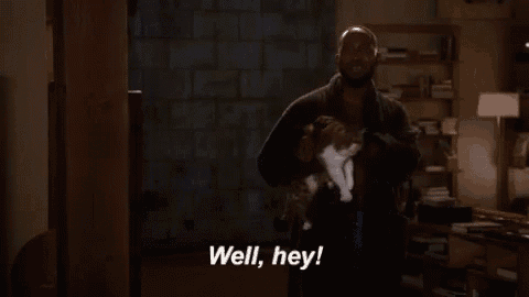 a man is holding a cat in his arms and says well , hey !