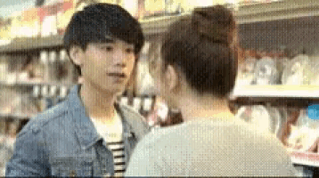 a man and woman are kissing in a store .