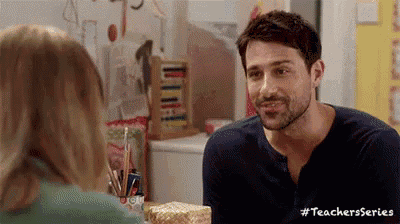 a man and a woman are talking to each other in a kitchen .