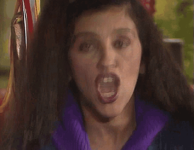 a woman with purple lips is making a face