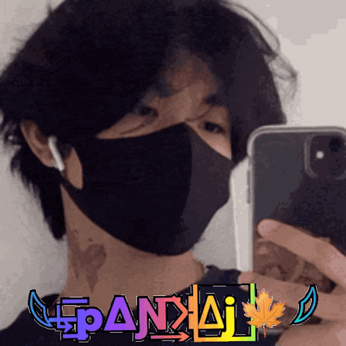 a man wearing a mask takes a picture of himself with the word pandai on the bottom left