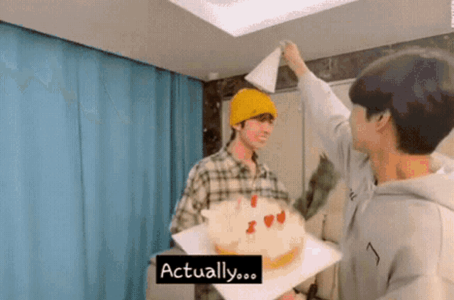 two men are standing next to each other holding a cake and one of them says actually