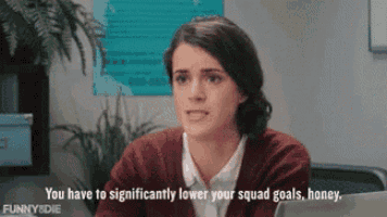 a woman is sitting in front of a laptop and says " you have to significantly lower your squad goals honey " .