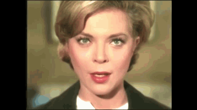 a close up of a woman 's face with a black jacket