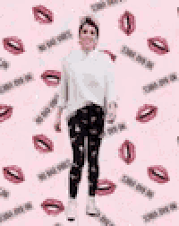 a woman in a white shirt and black pants is standing on one leg in a pink bubble .
