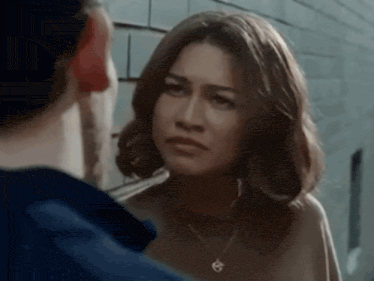 a man and a woman are looking at each other . the woman is wearing a necklace and earrings .