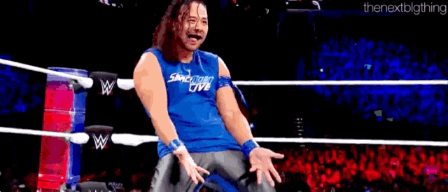 a wrestler wearing a blue shirt that says smackdown live on it