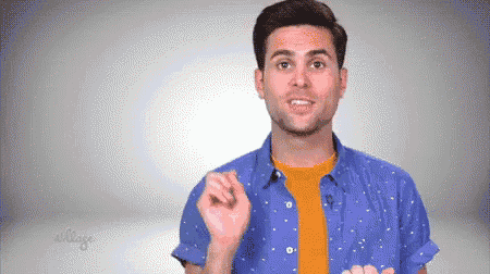 a man in a blue shirt and orange t-shirt is making a gesture .