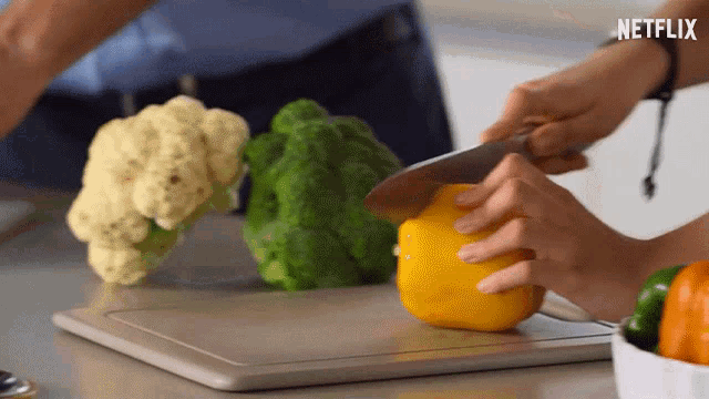 a person cutting vegetables on a cutting board with netflix written on the bottom
