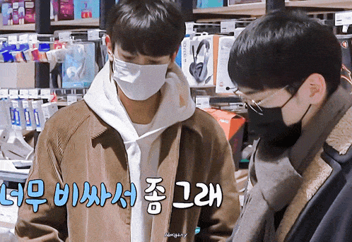 two men wearing face masks are looking at something in a store with chinese writing