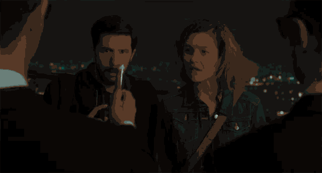 a man is taking a picture of a woman and a man with a flashlight
