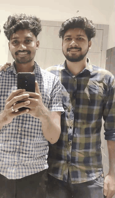 a man taking a picture of himself and another man