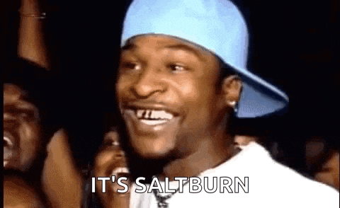 a man wearing a blue hat is smiling and saying `` it 's saltburn '' in front of a crowd .
