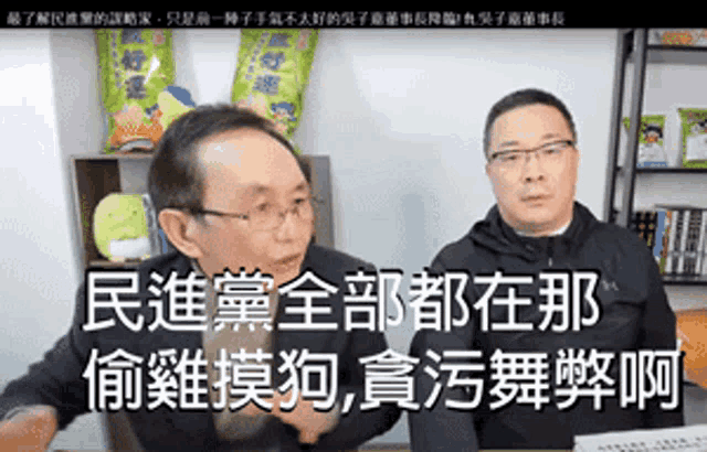 two men are talking to each other in a room with chinese writing