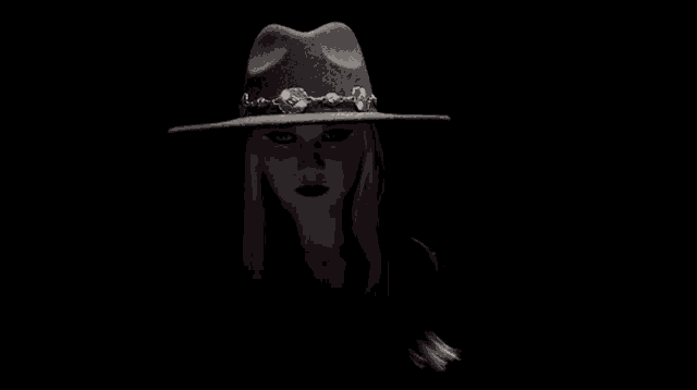 a woman is wearing a black hat with a chain around it