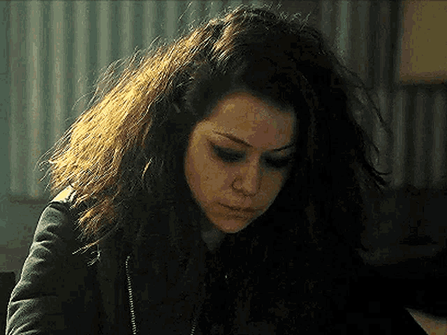 a close up of a woman 's face with a messy hairdo .