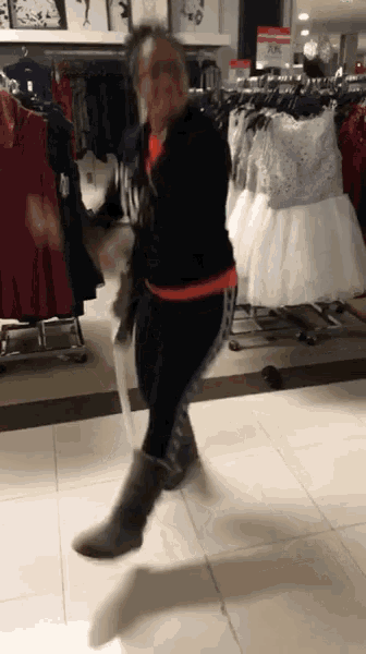 a woman is dancing in a store with a sign that says ' a & m ' on it