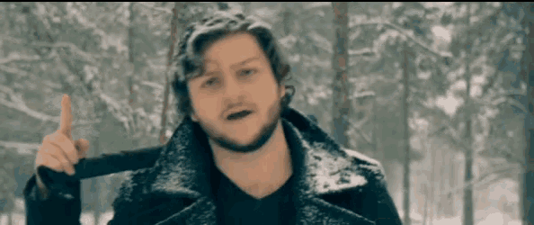 a man with a beard is standing in the snow holding a gun and pointing up