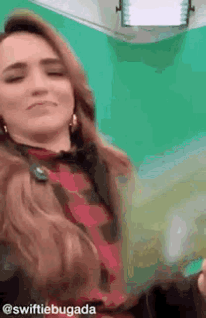 a woman is standing in front of a green screen .