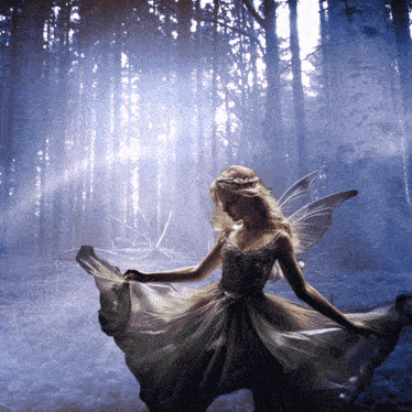 a woman in a dress with wings is dancing in the woods
