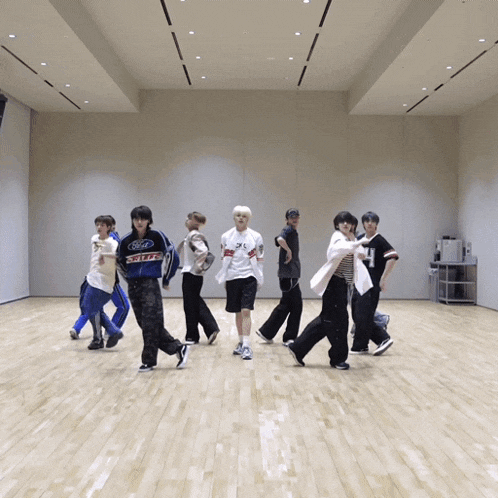 a group of young men are dancing in a room and one of them is wearing a jacket that says ford