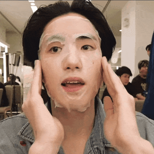 a man with a mask on his face holds his hands to his face