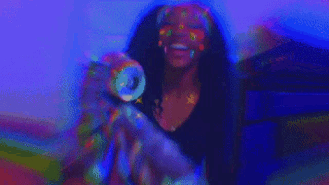 a woman wearing glow in the dark glasses and earrings is dancing in a club .