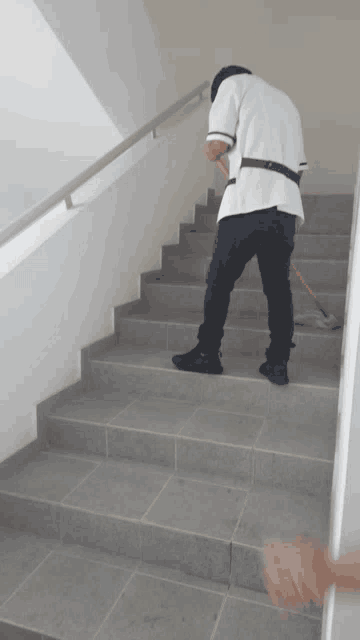 a man is cleaning the stairs with a mop