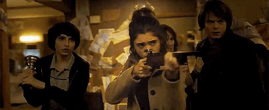 a group of people standing next to each other in a dark room holding guns .