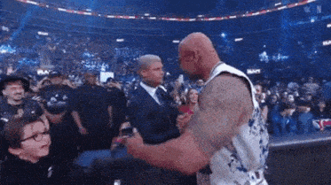 a man in a suit and tie is shaking hands with another man