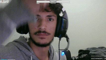 a man with a beard is wearing headphones and looking at the camera while playing a video game .